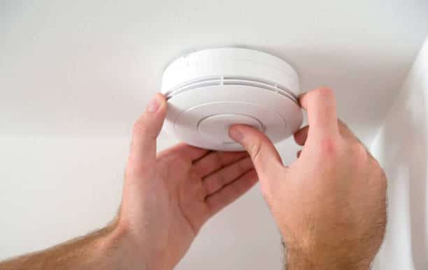 man installing smoke or carbon monoxide detector